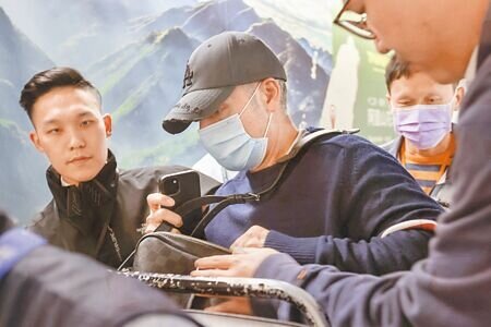 西班牙籍國際通緝犯奧納德(左二)20日晚間在移民署人員戒護下,搭機離台。(范揚光攝)