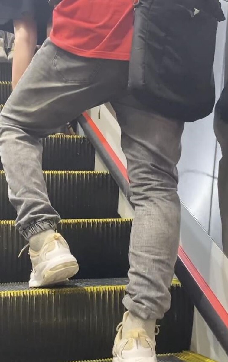 紅衣男子邊搭乘電扶梯邊尿尿。圖/翻攝自網路