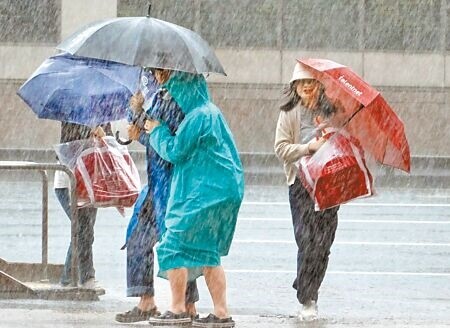 
康芮颱風10月31日襲台，北市街頭行人撐傘頂著強風豪雨賣力前行。（姚志平攝）
