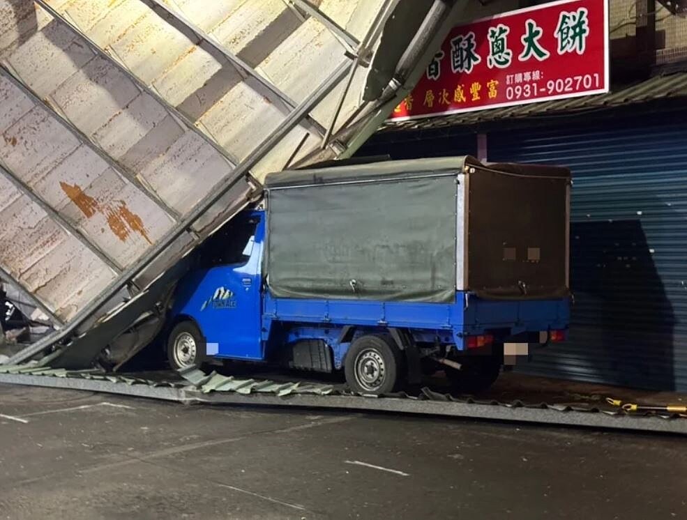 康芮強颱肆虐,新北市新莊區仁愛路晚間發生一整片鐵皮屋頂遭強風吹落,重壓路邊小貨車。記者王長鼎/翻攝