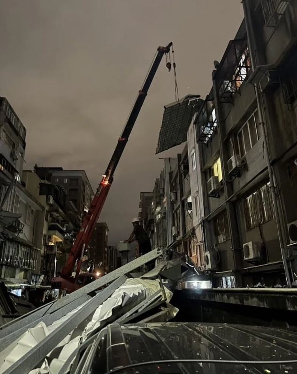 三軍總醫院在延壽街建物，大片屋頂鐵皮31日晚上遭強風吹落，建管處派遣拆除區隊與相關單位合力拆除清運。圖／台北市建管處提供
