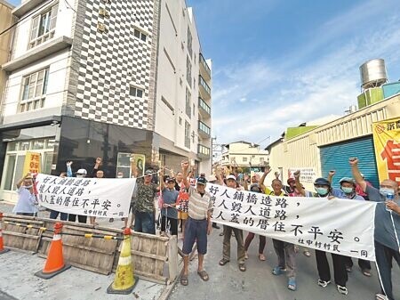 
屏東縣萬丹鄉社中村92歲莊翁不小心撞到「封路圍籬」受傷，不料卻反遭地主控告毀損並被傳去派出所做筆錄，村民一氣之下13日前往社皮所及事故地點舉白布條抗議。（謝佳潾攝）
