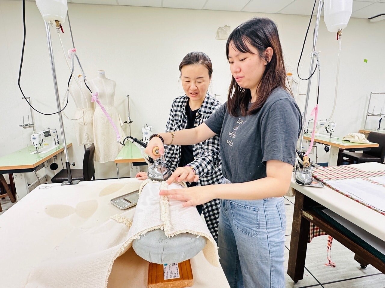 彭如瑩（右）車禍術後重生，在訓練師徐彥芬（左）的指導下考取服裝乙丙級，立志成為服裝樣品師。圖：勞動力發展署桃竹苗分署提供