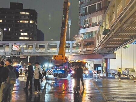 
台北市新生和平人行天橋19日晚間11時許開始拆除，守護和平新生天橋團體到場高舉「招魂幡」呼喊「懸崖勒馬、天橋不要拆」繞行天橋周圍抗議。（予菱攝）
