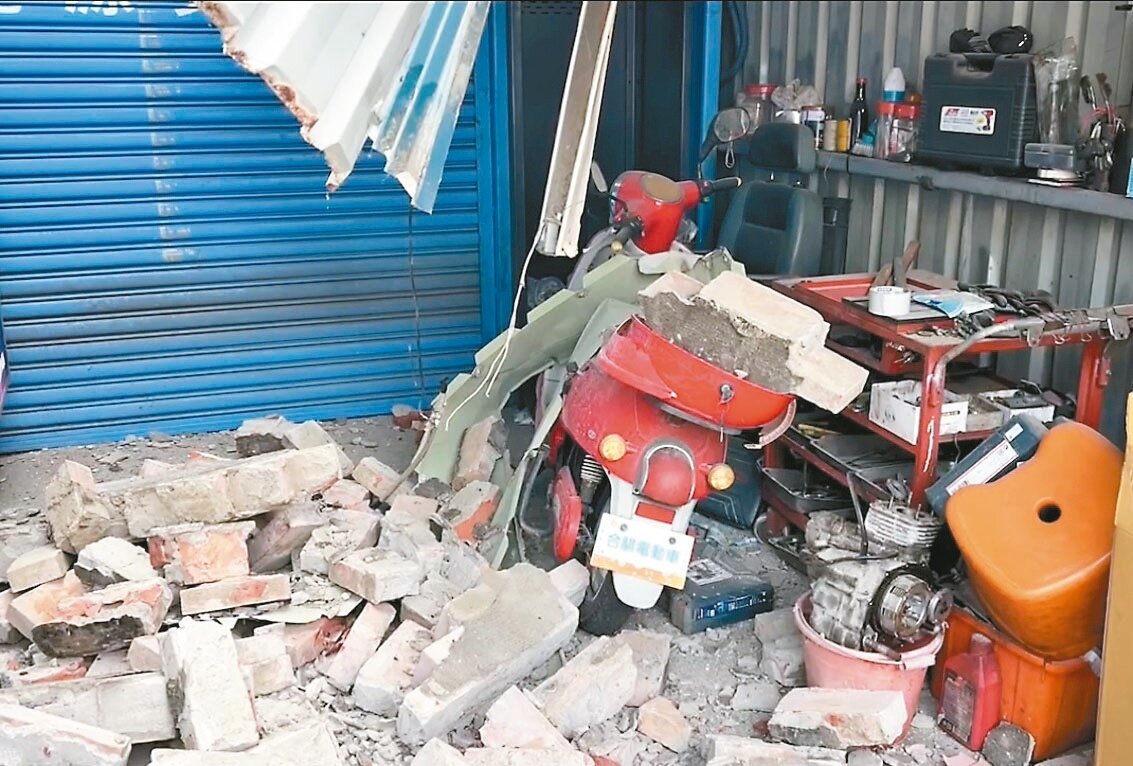 台南學甲區華宗路電池交換站被一旁樓頂翻倒的女兒牆壓毀,幸無人傷亡。記者周宗禎/攝影