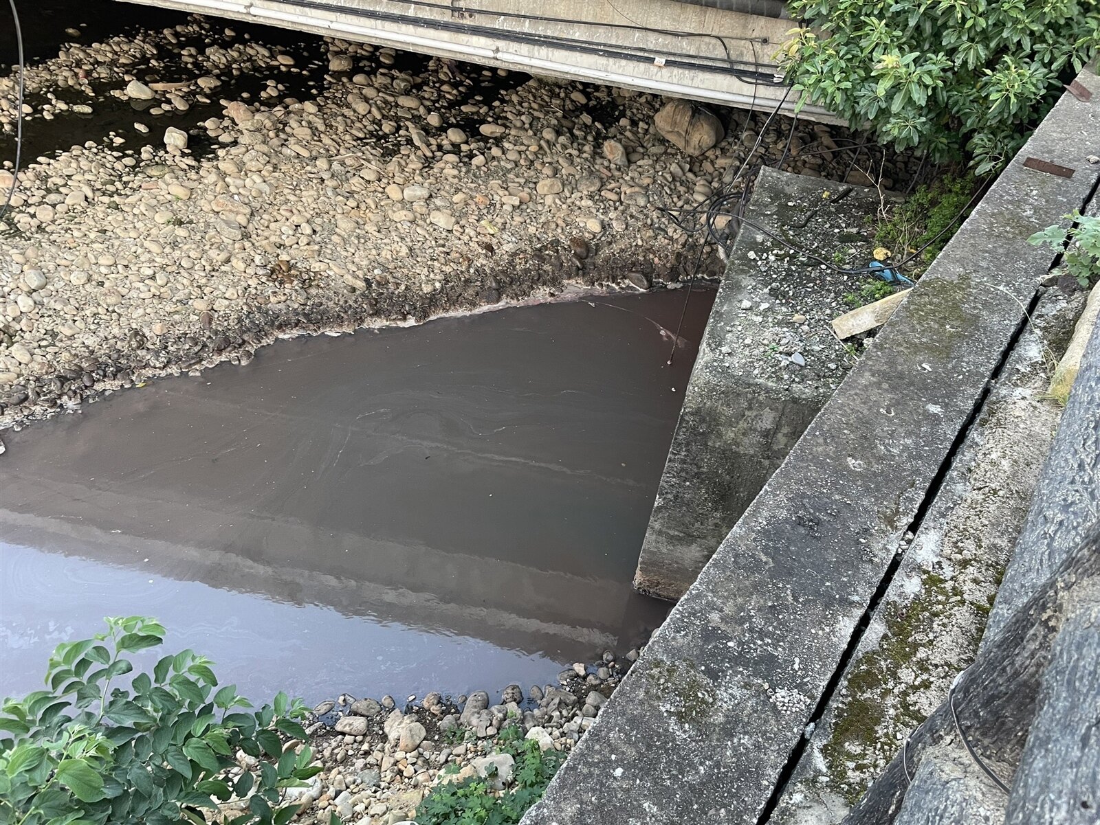 紅色漆料續流至下游五福橋下大坑溪產生明顯色差。圖:環保局提供