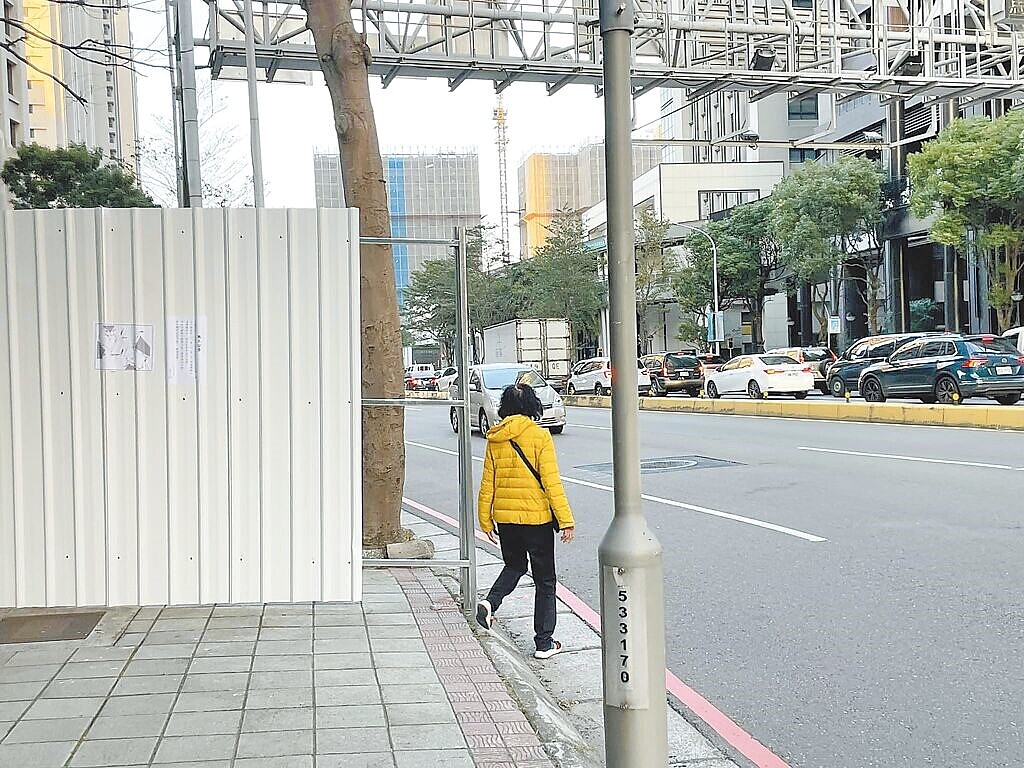 新竹市關埔空橋施工鐵皮圍籬切斷人行空間，行人被迫走在馬路上。圖／曾資程提供
