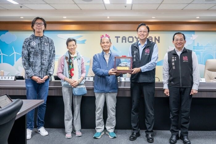 桃園市長張善政今日上午主持市政會議，頒發「黃鼎翔先生及黃簡映君女士賢伉儷家族捐贈復康巴士獎座」。圖：市府提供