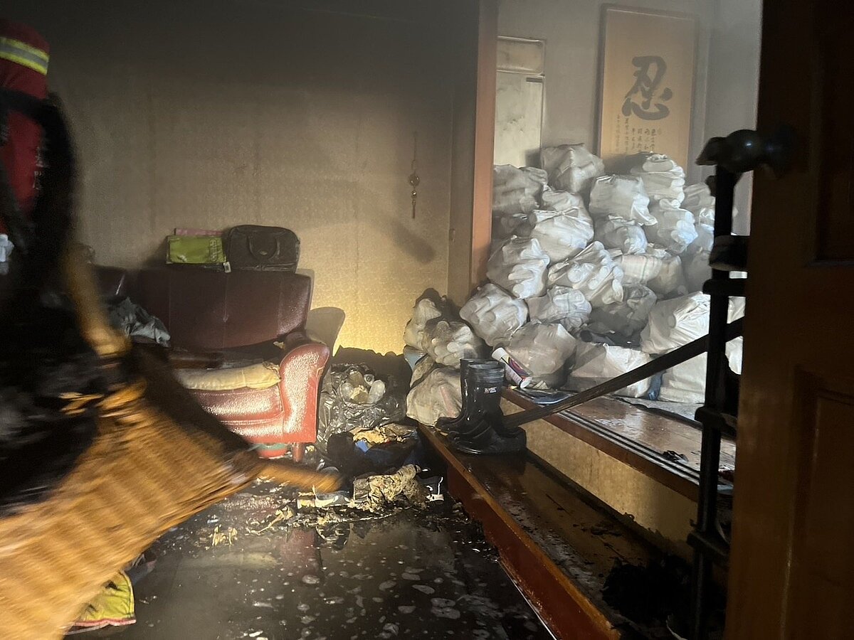 基隆永富路一處民宅4樓斷水電點蠟燭釀火警,消防人員到場灌救。圖/聯合報記者游明煌翻攝