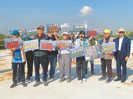 
高雄市林園工業區外魚塭廢墟的地主，9日舉牌向經濟部等相關單位表達抗議。（郭良傑攝）
