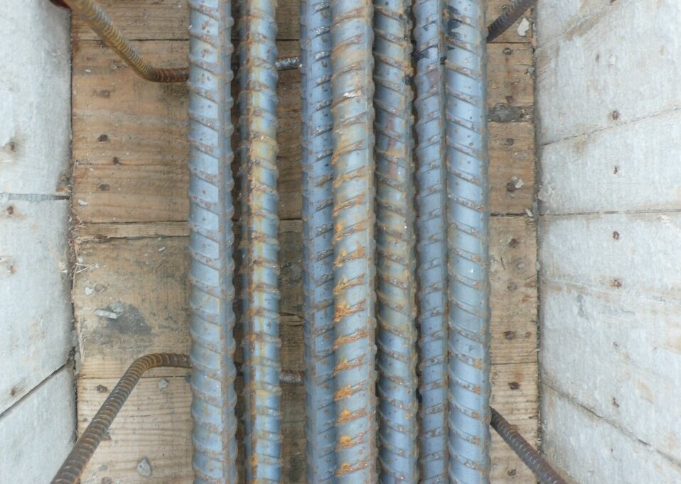 梁底鋼筋設計不當，造成梁筋過密重疊，混凝土無法充分包覆每一支梁筋，恐無法發揮應有之握裹力。