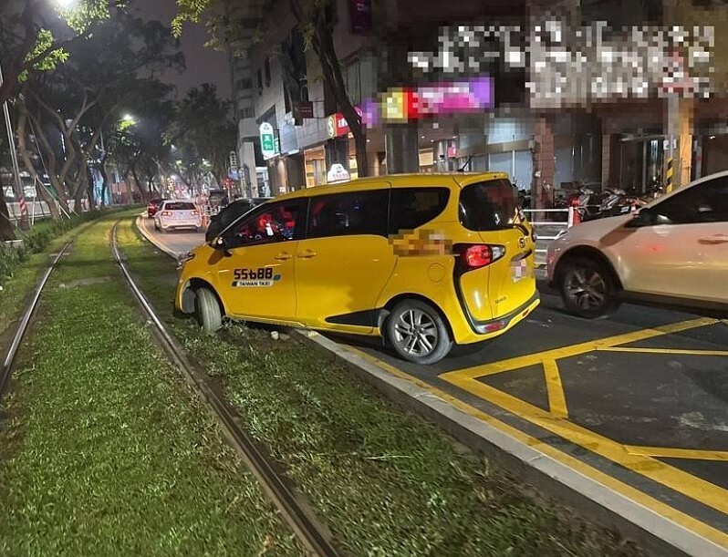 趙姓計程車司機前晚右轉大順二路425巷口，不慎駛入輕軌軌道，卡在泥濘草皮。圖／記者石秀華翻攝
