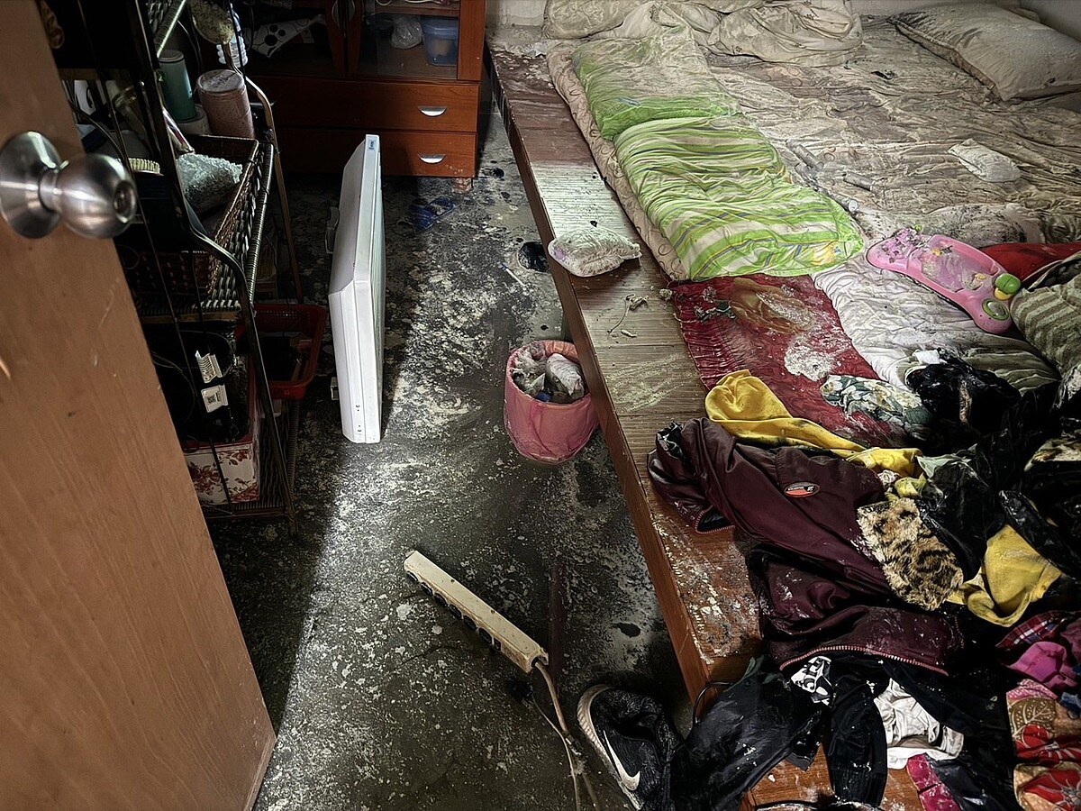 高市那瑪夏區一處民宅20日深夜傳火警,1樓房間疑延長線延燒至床鋪,所幸住警器發揮效用,在客廳滑手機的女屋主聽警報聲,呼叫5兒女逃生;圖為房間床舖及衣物被燒毀、燻黑畫面。圖/聯合報記者石秀華翻攝