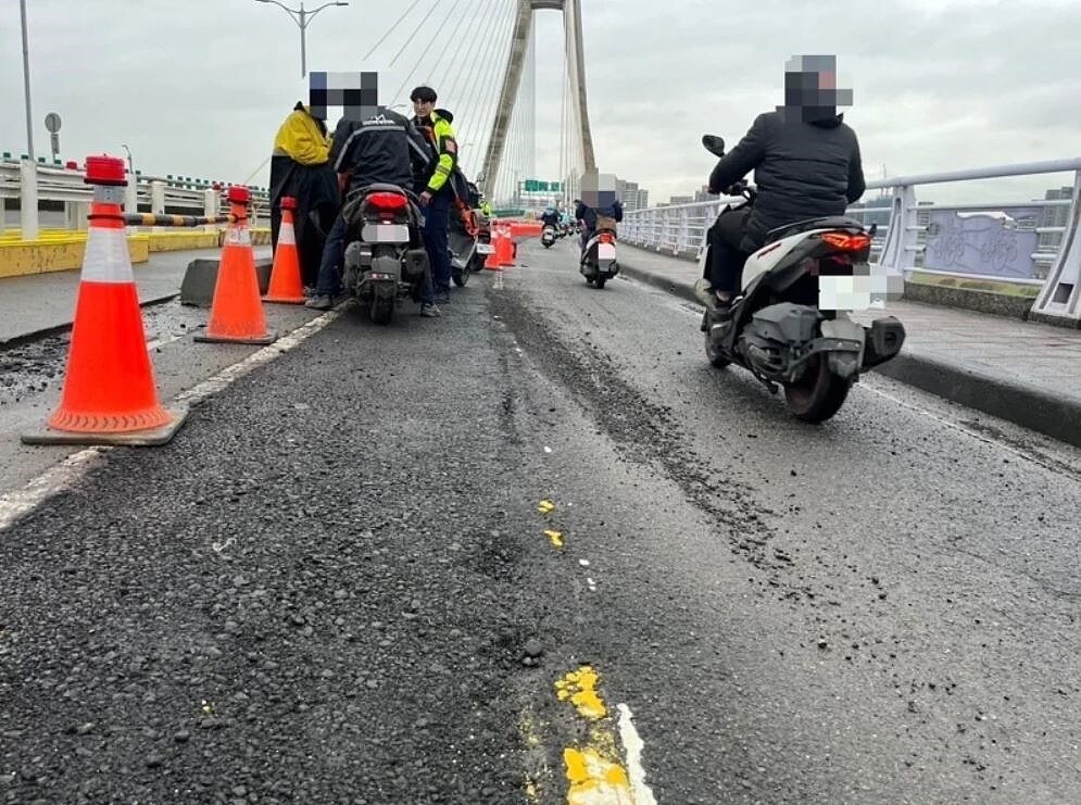 新北大橋早上出現多起機車摔車事故，疑與機車道改善工程有關，警方也到場交管。記者李成蔭／翻攝
