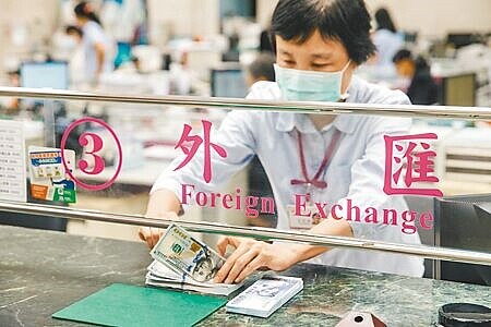 聯準會走往「降息之路」,美元一改近2年的獨強姿態,激勵亞幣絕地大反攻。圖為行員演示換兌情況。(本報資料照片)