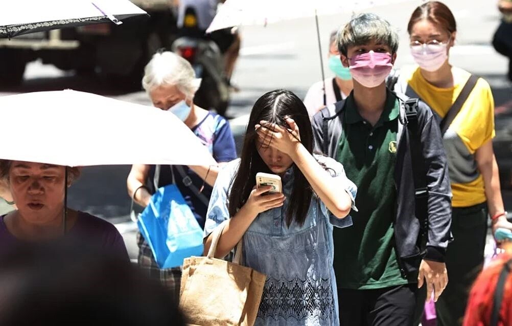 近日天氣高溫炎熱,雙北地區因熱島效應,曝曬在陽光下的體感溫度更是讓人大喊吃不消,走在路上的民眾除了用手用傘遮陽,也用盡各種方式降溫扺抗酷暑。圖與文/杜建重