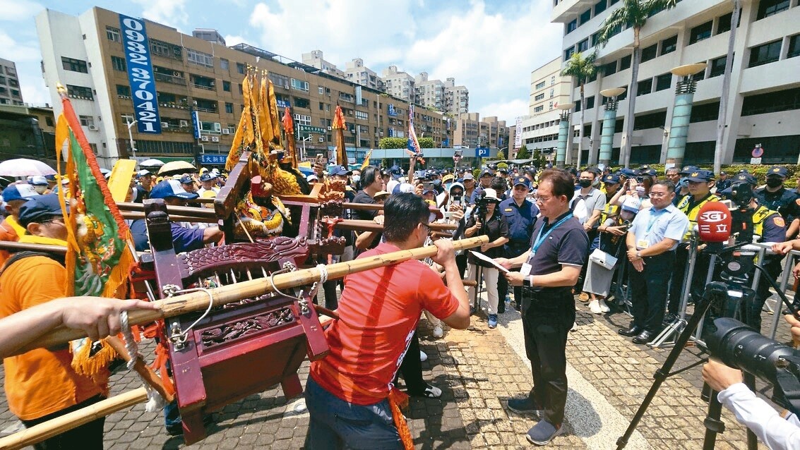 桃園航空城拆遷戶昨天帶著地方三大廟神尊到市府前陳情，市府地政局長蔡金鐘代表市政府接下神尊的陳情書。記者鄭國樑／攝影 