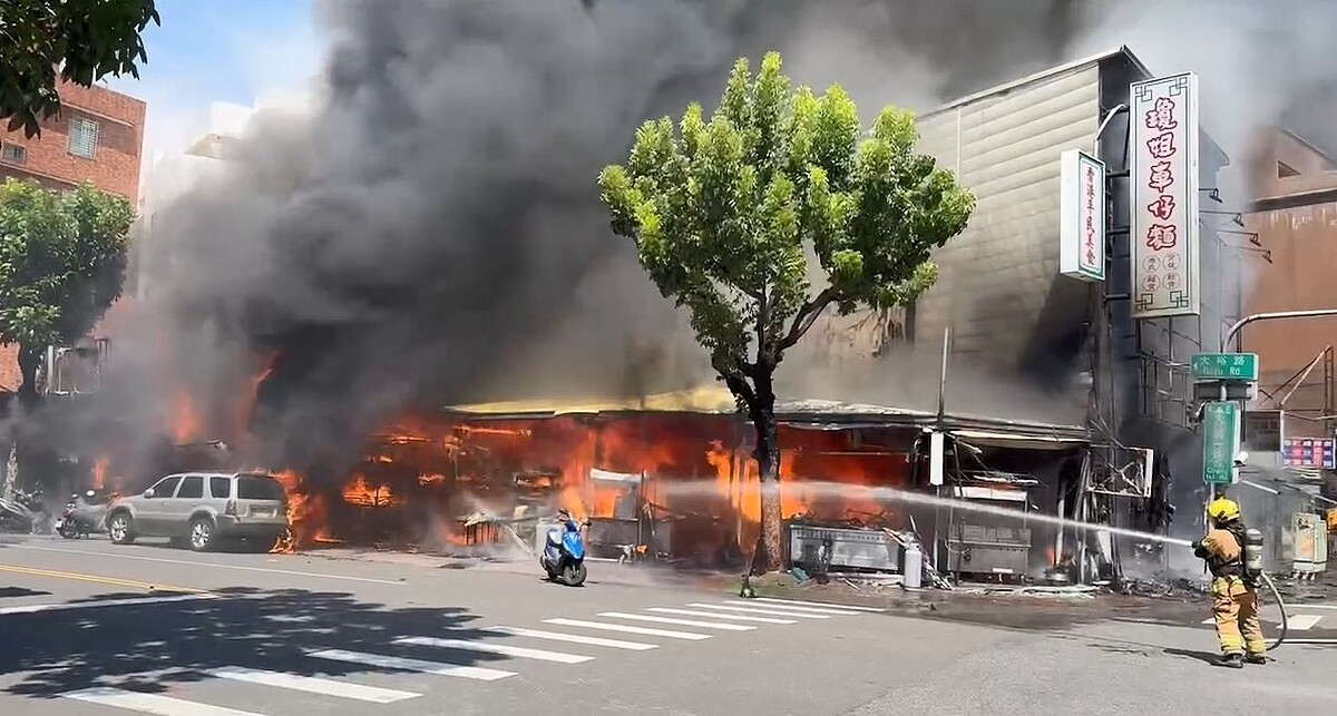 高雄市三民區大昌一路與大裕路口一家三角窗素食店，25日下午近2時許突然發生火警，火勢迅速悶燒，火煙像一團球向上竄燒，消防員在現場搶救。圖／記者石秀華翻攝