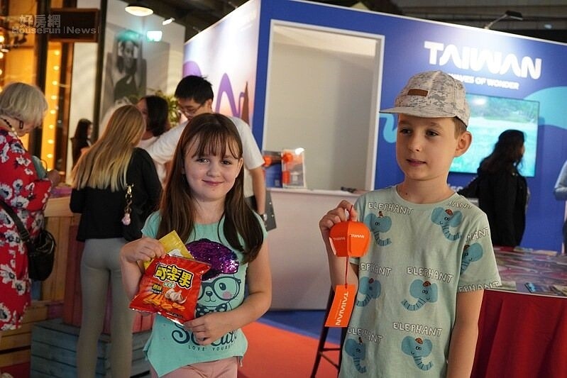 英國家庭旅客體驗台灣夜市彈珠台遊戲,開心兌換台味贈禮。(圖/觀光署提供)