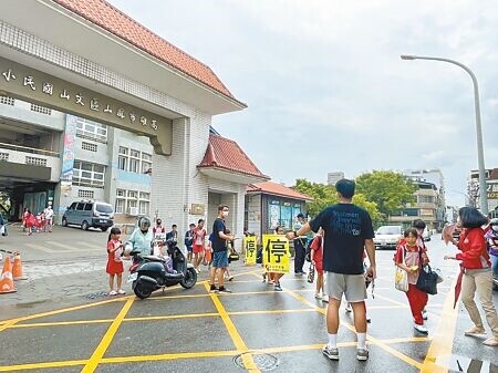 
高雄文山國小通學步道修建中，預計年底前完工，上放學時段由校方工作人員指揮交通。（紀爰攝）
