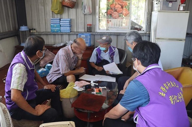 李男(左2)因病無法言語,僅能以紙筆跟彰化執行署人員溝通。圖/執行署彰化分署提供