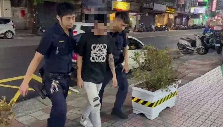 新北市三重區一所高職門口,13日下午驚傳3名學生遭校外人士持刀砍傷,警方帶回主嫌黃男查辦。圖/記者曾伯愷翻攝