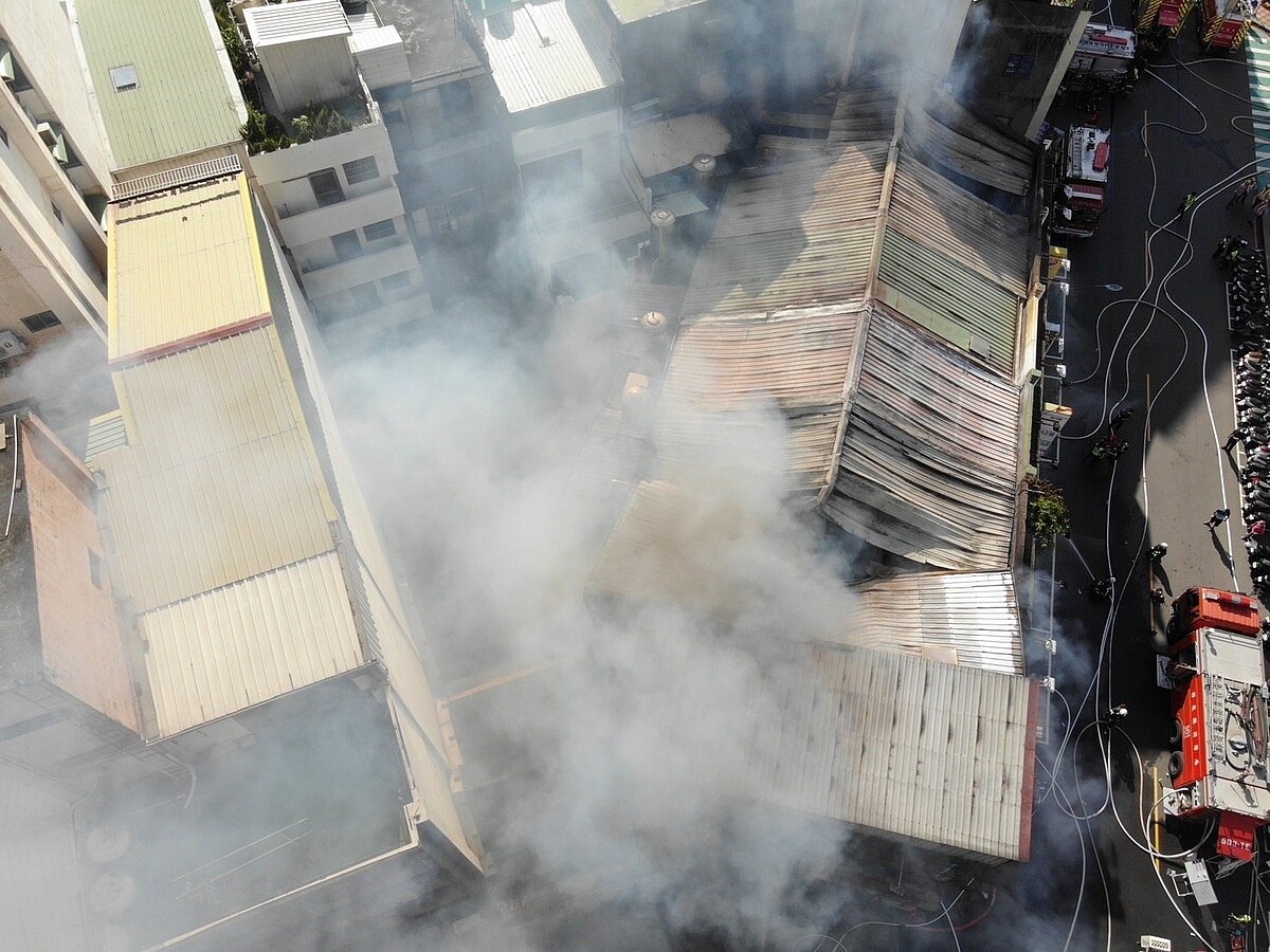 彰化市鬧區長安街7月18日發生大火，連燒10棟樓，消防人員指出，火勢沿頂樓鐵皮屋延燒是主要禍首，縣府擬朝自主都市更新辦理災後重建。圖／消防局提供