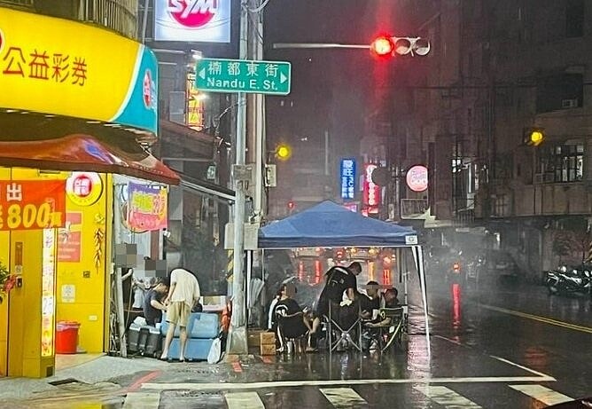 有網友拍下高雄民眾在楠梓區楠都東街的路口紅綠燈下搭棚烤肉畫面。圖/取自高雄大社、楠梓、燕巢、仁武生活交流圈