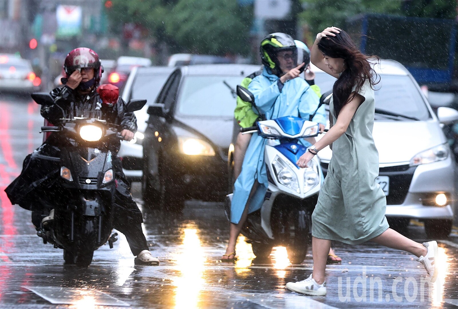 今明兩天熱帶性低氣壓及低壓帶影響全台，各地易有短延時強降雨，而台北地區今整日雨勢不斷，未備雨具的民眾在雨中快步通過行人穿越道。記者侯永全／攝影 