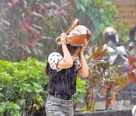 
中央氣象署昨持續發布豪大雨特報，受熱帶性低氣壓及低壓帶影響，大台北地區中午降下強降雨，未帶雨具的民眾拿起包包遮擋，快跑過街。（黃世麒攝）
