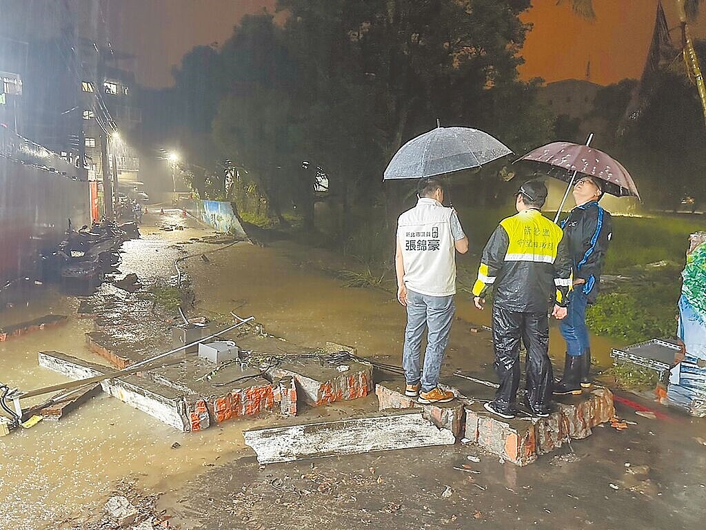 位在新北市汐止區的經濟部標準檢驗局電氣檢驗大樓園區，22日晚間疑因園區內抽水機故障，導致大量積水沖垮圍牆，汐止區長林慶豐（右一）、議員張錦豪（左一）到場了解狀況。圖／議員張錦豪提供