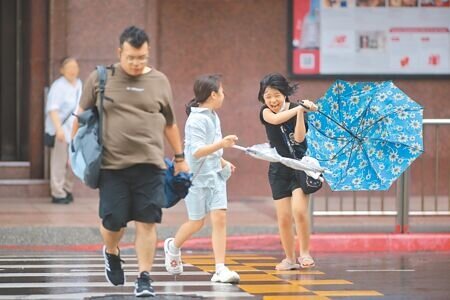 山陀兒颱風雖然威力減弱,但北部市區的間歇性雨勢及強風,依舊讓外出民眾吃足苦頭。(郭吉銓攝)