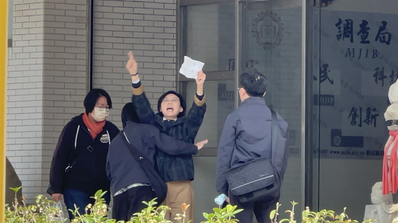 林岱樺被帶進調查局南部機動組時，對著媒體大喊「政治干預司法、司法干預初選」。記者張議晨／攝影 