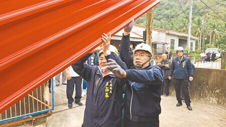 台南市長黃偉哲20日到楠西區密枝里慰問作工行善團志工,並協助搬運屋簷材料上梁。(程炳璋攝)