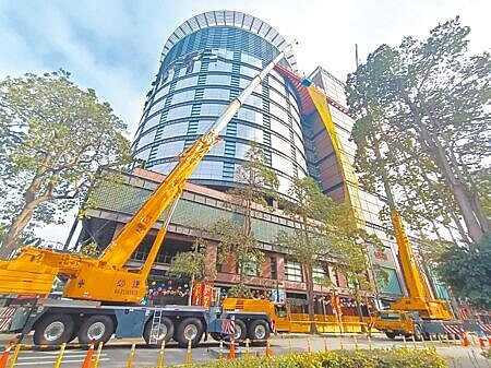 台中市新光三越外牆附掛物仍有公安疑慮,都發局限期25日前拆除改善,業者24日在外牆設置防護網以利作業,同時也向都發局申請展延。(陳淑娥攝)