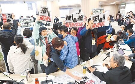 
基隆協和電廠四接環評大會26日在環境部舉行，環保團體衝到台前，高舉標語抗議環評違法會議無效，場面混亂。（姚志平攝）
