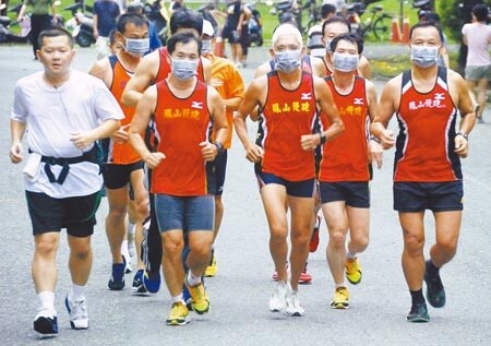鳳山慢跑協會成員戴上口罩試跑,發現口罩被汗水沾濕後難以透氣,跑到一半就氣喘吁吁。(林宏聰攝)