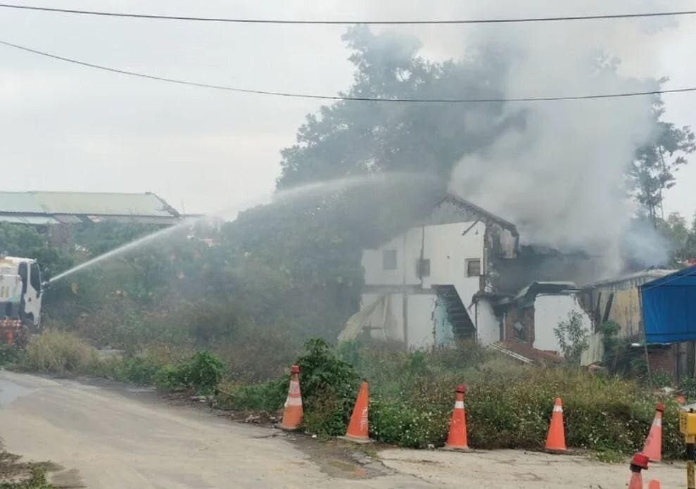 高雄市地政樹土開處人員6日下午3時許在大寮區影七路清除老舊眷村拆除的地上物,舉辦法會燃放鞭炮,不慎引發火勢,消防員在現場射水線灌救。圖/讀者提供