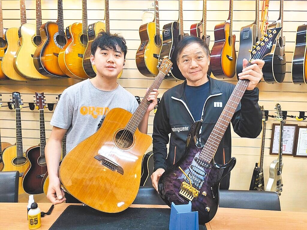 台中各家樂器行受金屬價格、運費飆漲影響生存不易,豐原樂器行老闆鄭啟富(右)仍無償提供200把吉他給台中、苗栗10所國中高使用,藉此推廣音樂。圖/李京昇攝