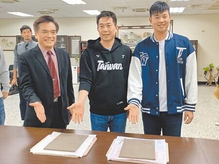 台灣隊投手黃子鵬(右)和投手教練林岳平(中),26日回母校五福國中,與校長何茂通(左)合影並留下「冠軍手印」,此拓印裝框後將陳列在傑出校友櫥窗,作為榮耀象徵。(郭良傑攝)