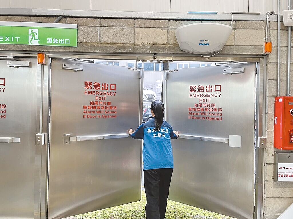 農曆春節將至,新北市工務局稽查轄內64家大型商場、百貨公司的設備安全,圖為檢查人員正在稽查緊急出口是否能夠正常閉合。圖/新北市工務局提供