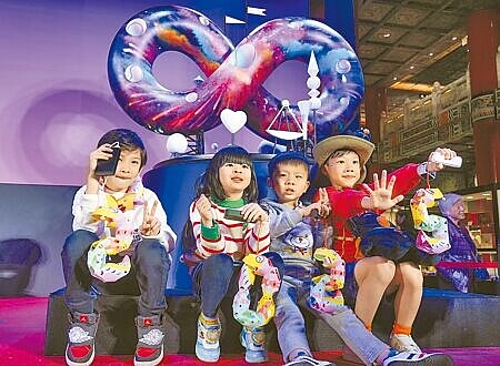 交通部觀光署3日在圓山大飯店舉行「2025台灣燈會」主燈暨小提燈造型發表記者會,會後小朋友前來與主燈「無限樂園」模型合影留念。(羅永銘攝)