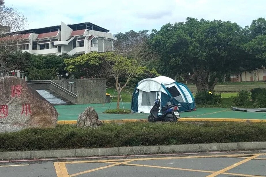 宜蘭難得放晴，竟有民眾跑去學校門口，大剌剌地「曬帳棚」，一度被以為搭棚露營，有人拍下照片向校方反映，當事人才收起帳棚離去。圖／讀者提供
