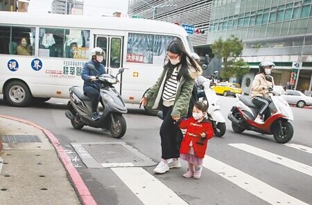 
2名行人走過斑馬線，轉彎車輛紛紛停讓。（本報資料照片）
