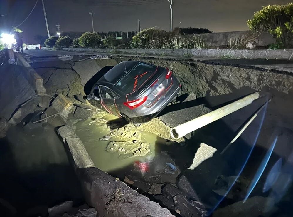 嘉義縣布袋鎮龍宮溪支流的防汛道路前晚坍塌出現天坑,1輛汽車不慎掉入,縣府已封路搶修。記者黃于凡/翻攝
