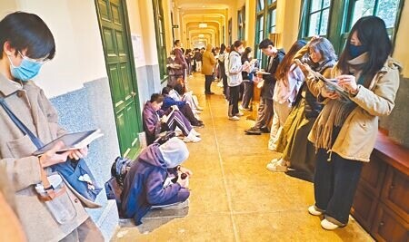 大學學測19日邁入第2天,主科國文、英文登場,各地天氣明顯轉冷,考生穿著厚重衣物在考場走廊複習做最後衝刺。(陳君瑋攝)