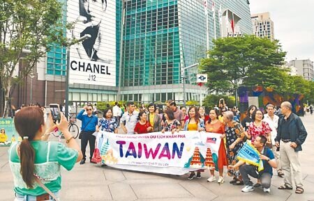圖為東南亞旅行團在台北市101大樓前合影。(本報資料照片)