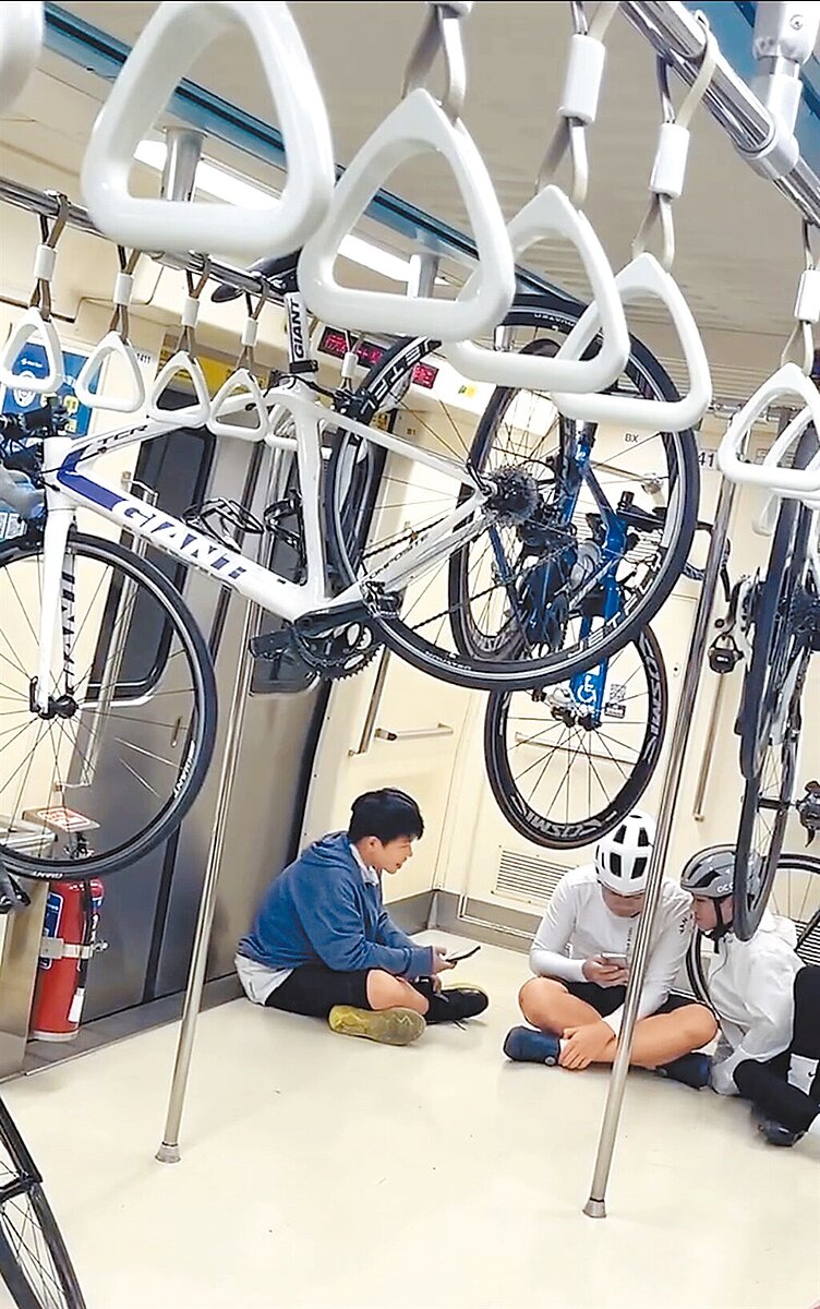 有民眾在thread發文,指出有3名單車族在搭乘台北捷運時,把自行車懸掛在捷運車廂內拉環上方橫桿上,搖搖晃晃相當危險。(民眾提供/丁上程台北傳真)
