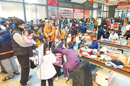 
民眾搶打流感疫苗，新北市新莊宏匯廣場開設臨時接種站大排長龍，排首位的1組家庭清晨4時就到場。（黃世麒攝）
