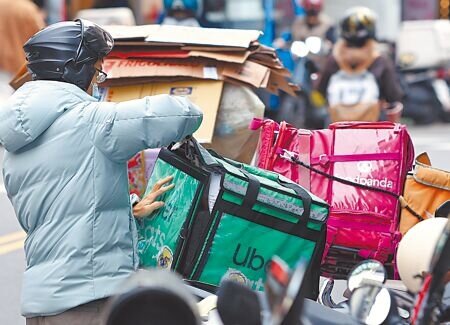 外送雙雄foodpanda與Uber Eats合併案,去年底遭公平會否決,仍維持各自爭霸局面。圖為Uber Eats、foodpanda外送員外送情形。(本報資料照片)